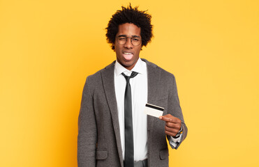 young black afro man feeling disgusted and irritated, sticking tongue out, disliking something...