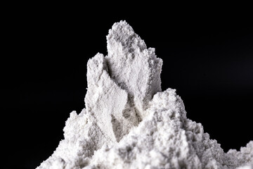 Kaolin on black isolated, powdered background. Kaolin is a mineral of inorganic constitution,...