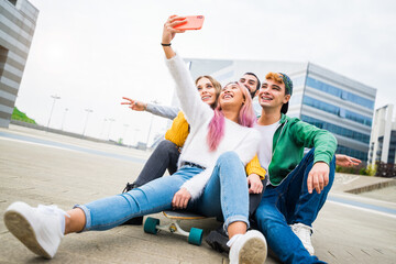 Multiracial friends taking selfie at skate park - Happy youth and friendship concept with young millenial people having fun together in urban city area - Powered by Adobe