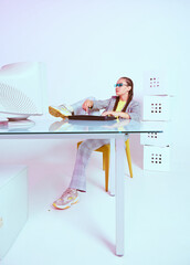 Stylish asian female creative office worker or confident chief sitting at old computer with leg on...