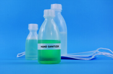 Hand sanitizer gel with protective face mask stock images. Protective equipment against COVID-19. Sanitizer gel bottle with medical mask isolated on a blue background stock photo