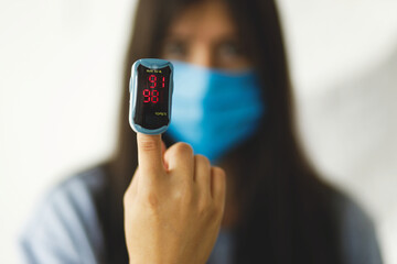 Detecting coronavirus at home, injury lungs and pneumonia by virus. Pulse Oximeter on hand