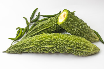 Sliced bitter melon with chili pepper on white background