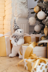  beige teddy bear and christmas gifts under the christmas tree