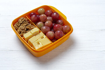 Food in Plastic containers ready to eat with Cheese, grapes and nuts