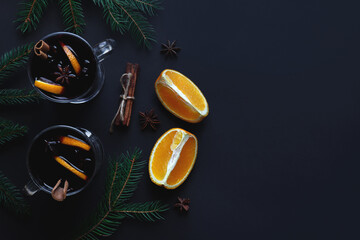 Flat lay with two glasses of mulled wine, Christmas tree branches, cinnamon, anise and oranges on...