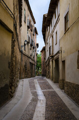 Obraz premium Traditional houses in a narrow street of the mediaeval village of Molina de Aragón on a cloudy day, Guadalajara, Spain