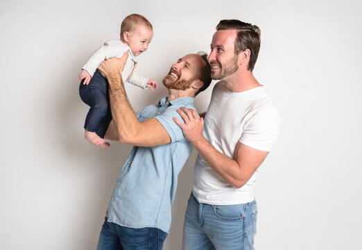 Gay Or Homosexual Male Couple With Their Daughter Baby Over White Background