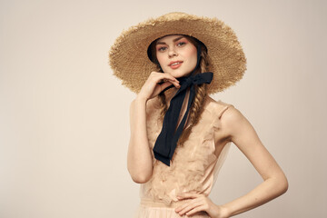 romantic girl in beige dress and in straw hat with black ribbon emotions portrait of model cropped view