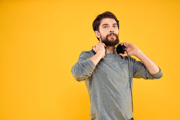Man in headphones listens to music technology lifestyle fun people yellow background