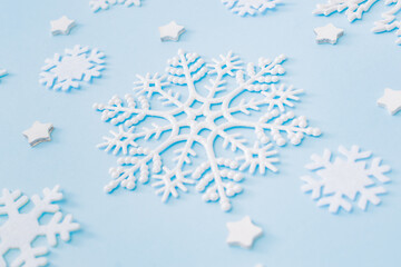 Flat lay christmas pattern with snowflakes on a blue background