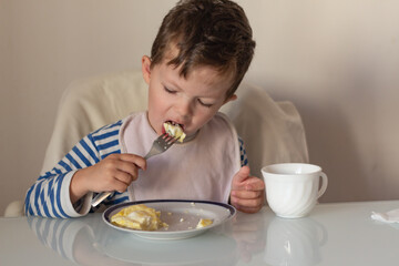 small child eats amlet Breakfast copi space