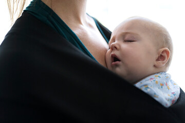 young mother with her daughter in sling Baby Carrier