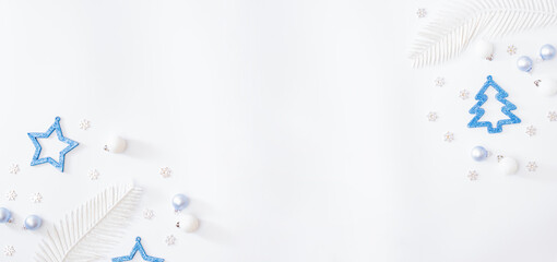 Flat lay frame with christmas baubles decoration and snowflakes on a white background