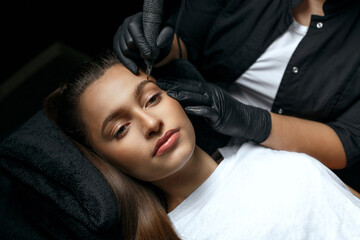 Makeup artist applying eyebrow permanent makeup