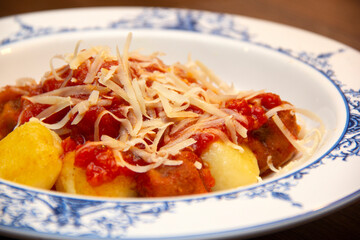 Gnocchi. Roasted Italian pasta with tomato sauce, parmesan cheese and meatballs.