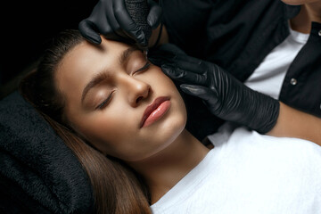 Beauty master making permanent brow makeup - obrazy, fototapety, plakaty