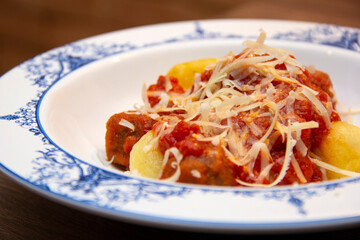 Gnocchi. Roasted Italian pasta with tomato sauce, parmesan cheese and meatballs.