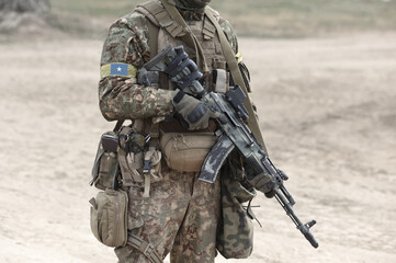 Soldier with machine gun and flag of Somalia on military uniform. Collage.
