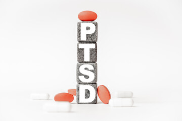 a group of white and red pills and cubes with the word PTSD Post-traumatic stress syndrome on them,...