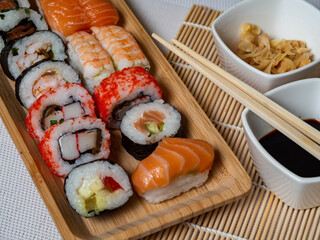 Japanese sushi food. Maki ands rolls with tuna, salmon, prawns, crab, and avocado. Top view of a variety of sushi. Colorful roll of sushi, uramaki, hosomaki and nigiri on wooden trays.