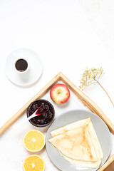 View of the morning breakfast with pancakes and fruits. Flat lay on a flavored snack on a tray