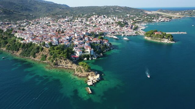 Aerial drone video of picturesque main town of Skiathos island featuring small landmark peninsula of Bourtzi, Sporades, Greece