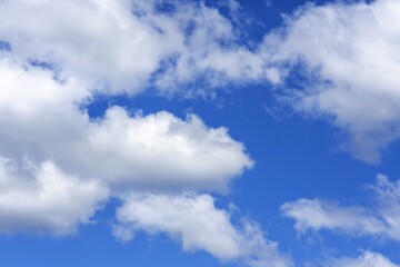 Naklejka na ściany i meble white cumulus clouds against a bright blue sky