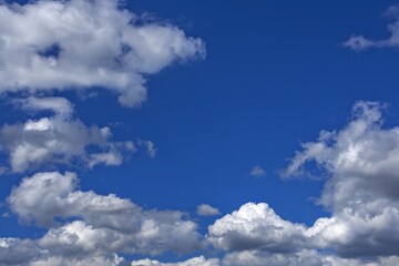 Naklejka na ściany i meble white cumulus clouds against a bright blue sky