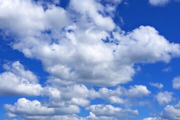 white cumulus clouds against a bright blue sky