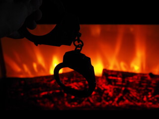 Handcuffs against the fireplace in the dark.