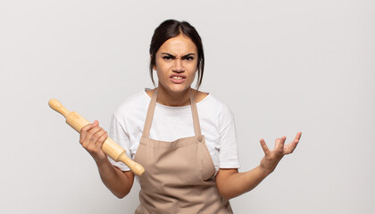 young hispanic woman looking angry, annoyed and frustrated screaming wtf or what’s wrong with you
