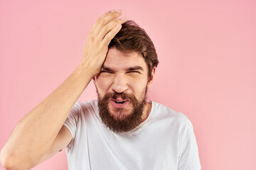 Man in white t-shirt gestures with hands emotions lifestyle cropped view pink background