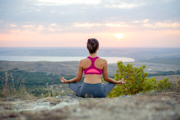 Fototapeta na wymiar young pregnant woman does yoga outdoors. Yoga at sunset