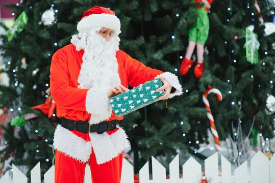 Portrait real authentic Santa Claus with Christmas gifts in hands in Shopping Mall