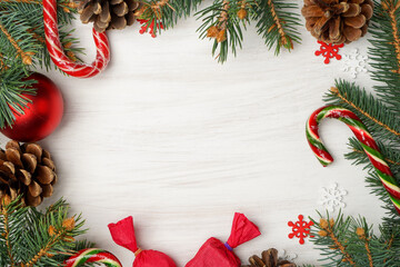 Christmas card with Christmas tree branches, pine cones, candy cane, Christmas toys and copy space