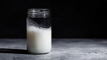 Ayran Turkish sparkling yogurt drink in glass jar on dark background. Healthy probiotic beverage