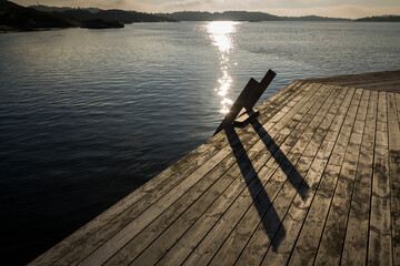 Horizontal view of a wooden jetty and ladder that descends into the ocean in Kopstadso, a small...