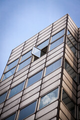 Vertical Detail Of Facade Of Abandoned Modern Building With One Mysterious Open Window. Looking Up At Open Window In Building.	