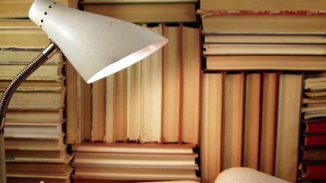 Books, lamp and thick writing-book with handwritten English text on the desk