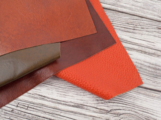 Natural leather textures samples on light wooden background