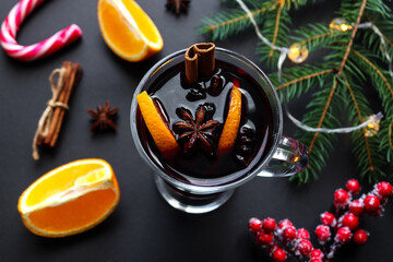 Glass of mulled wine with cinnamon, anise and oranges on a festive Christmas background. Christmas drinks, winter concept. Flat lay, top view, close-up, selective focus