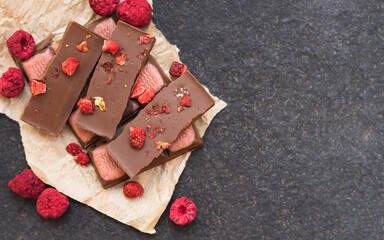 Chocolate bars handmade with strawberries and pistachios on a black background. Craft vegan chocolate