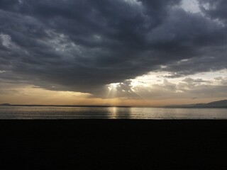 black clouds over the sea and the sun