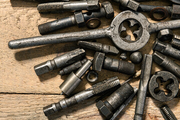 Old vintage drills and threading die tools on a wooden background