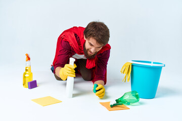 A man with cleaning supplies in a red raincoat on the floor of a home interior professional