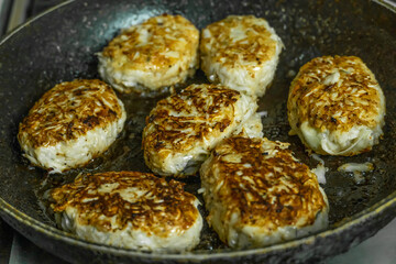 Homemade cutlets are fried in a frying pan close-up in the home kitchen. Homemade food