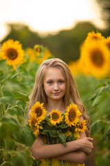 Cute teenage girl in yellow dress on the field with sunflowers