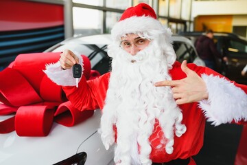 Authentic Santa Claus driving red car, view from outside