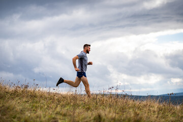 handsome trail runner running in nature © Melinda Nagy
